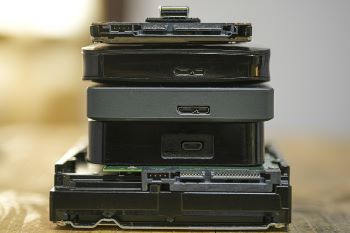 A stack of old memory storage devices and tech components on a wood surface