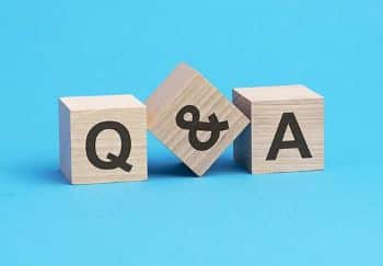 Three wooden cubes on a blue background. Each block has a different black letter, spelling Q&A.