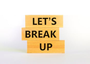 3 blocks of wood on a white background stacked on top of each other with one all-caps word in black text on each that read, "Let's Break Up" from the top down