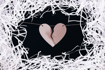 A ripped paper heart surrounded by shredded paper.