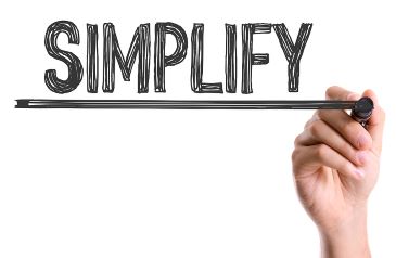Hand with marker writing the word Simplify