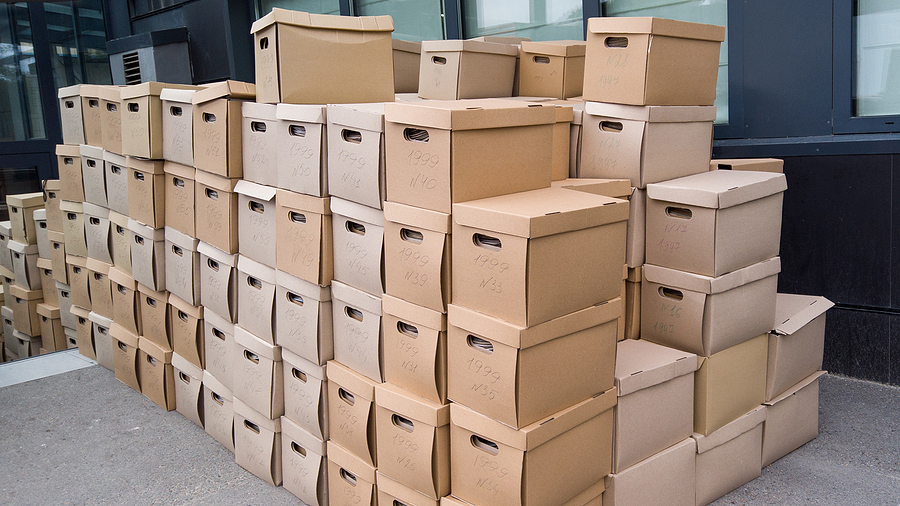 Dozens of document storage boxes are piled in an office space.